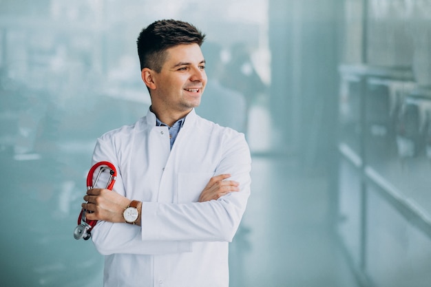 Foto grátis jovem médico bonito em uma túnica médica com estetoscópio