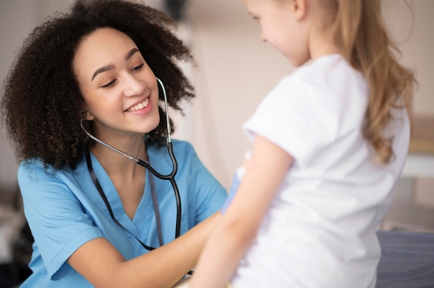 Jovem médico certificando-se de que a menina está bem após a vacinação