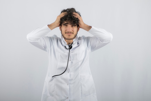 Jovem médico chateado se esqueceu de algo e levou a mão à cabeça.