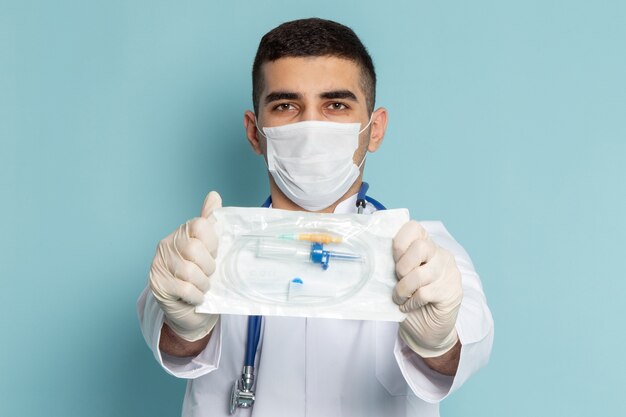 Jovem médico masculino de terno branco com estetoscópio azul