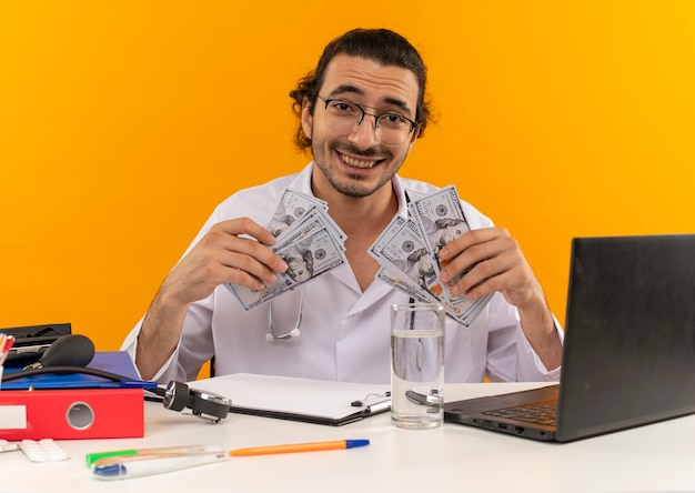 Jovem médico sorridente com óculos médicos e roupão médico com estetoscópio