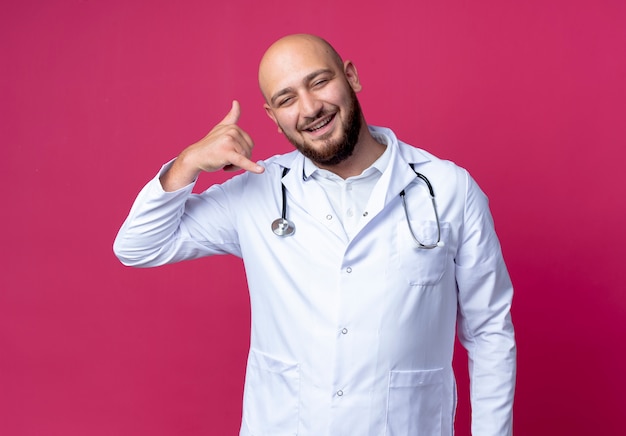 Jovem médico sorridente, vestindo bata médica e estetoscópio, mostrando uma ligação