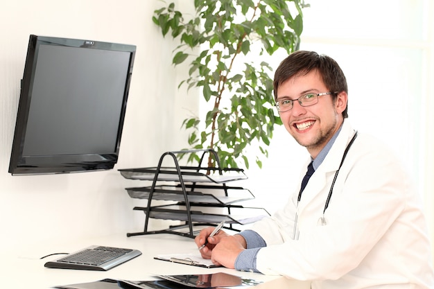 Foto grátis jovem médico trabalhando em seu escritório