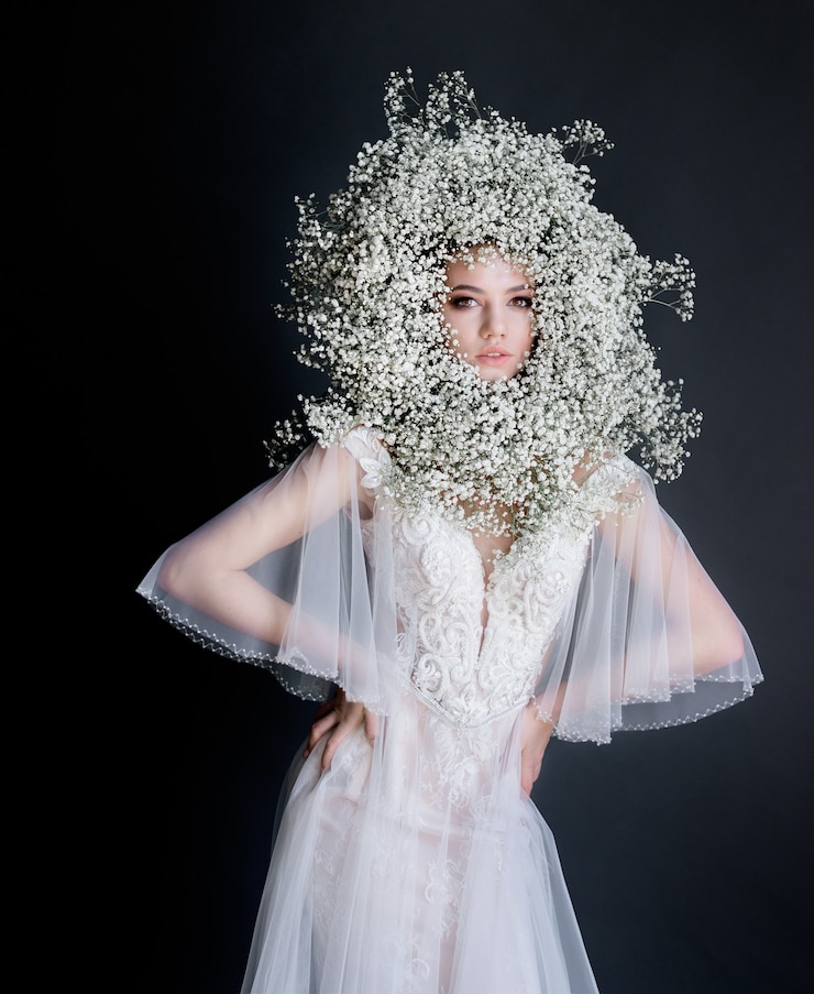 Foto grátis jovem menina bonita com coroa de gypsophila fresca no rosto vestido com vestido branco e concurso no fundo escuro