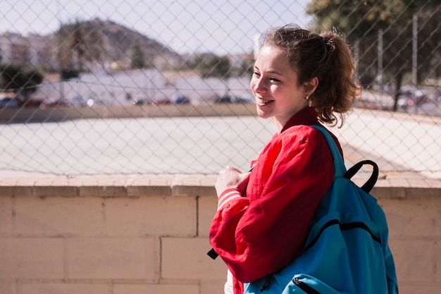 Foto grátis jovem menina bonita em pé perto de sportsground