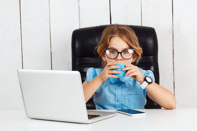 Jovem menina bonita sentada no local de trabalho no escritório.