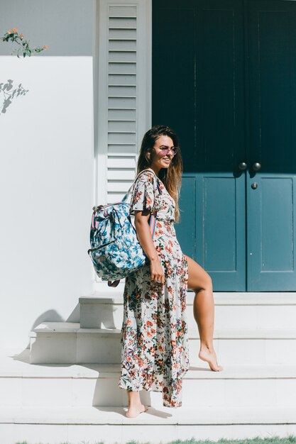 jovem menina linda posando na rua em um vestido com uma mochila