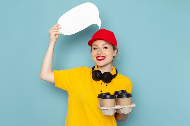 Jovem mensageira de frente para mulher de camisa amarela e capa vermelha segurando xícaras de café cartazes brancos no espaço azul