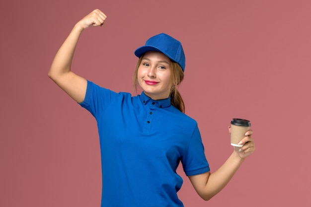 Jovem mensageira de uniforme azul posando de frente para uma xícara de café, entrega de uniforme de serviço, mulher, trabalho, foto trabalhador