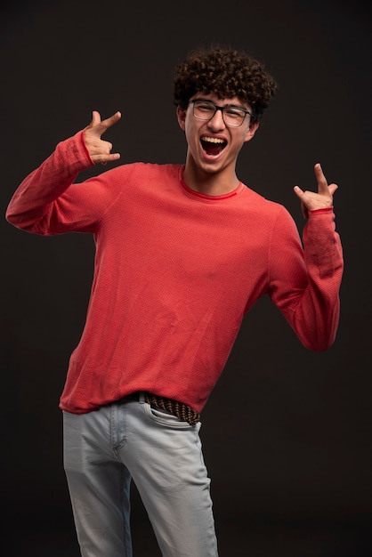 Jovem modelo de camisa vermelha posando em peças fundidas gritando.