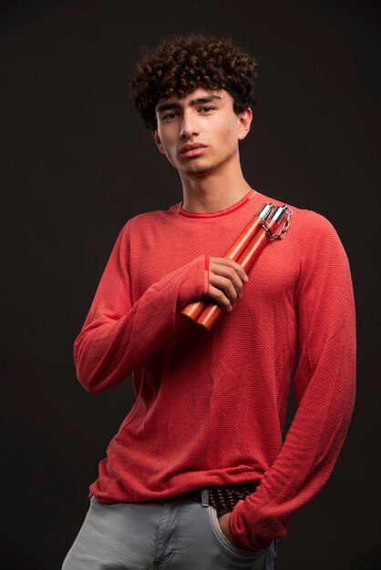 Jovem modelo de camisa vermelha, segurando o equipamento de esporte.