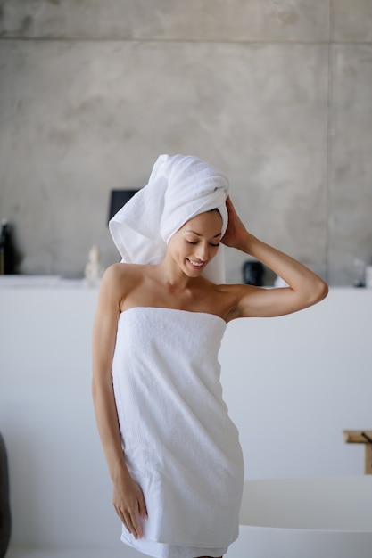 Foto grátis jovem modelo feminina caucasiana relaxada em uma toalha branca