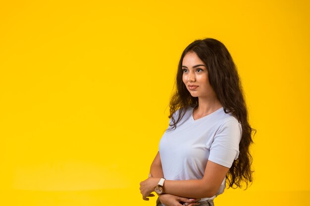 Jovem modelo posando na superfície amarela