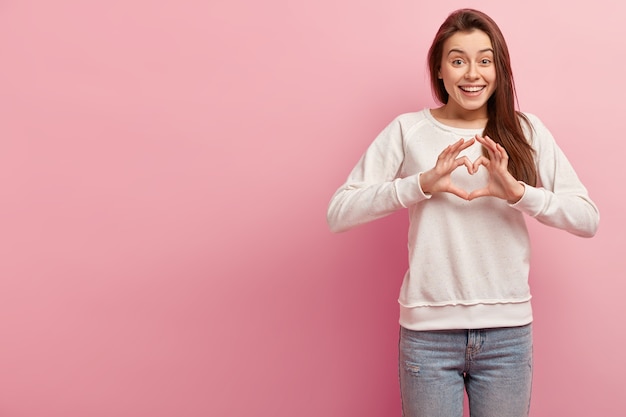 Foto grátis jovem morena de jeans e suéter