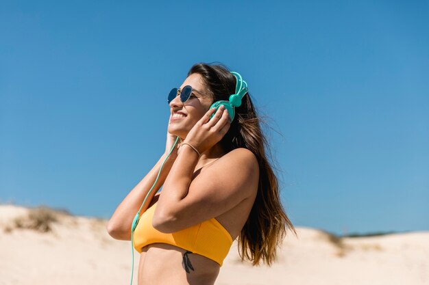 Jovem morena ouvindo música em fones de ouvido