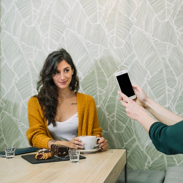 Jovem morena posando para foto no café