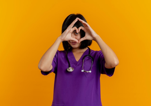 Foto grátis jovem morena satisfeita com a médica de uniforme com estetoscópio