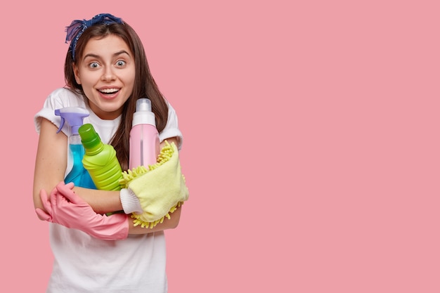 Jovem morena segurando produtos de limpeza