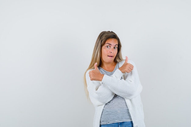 Foto grátis jovem mostrando dois polegares para cima em t-shirt, jaqueta e parecendo feliz, vista frontal.