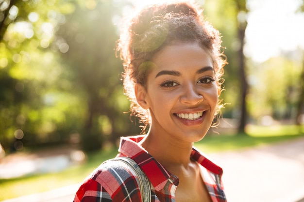 Foto grátis jovem mulher africana caminhando ao ar livre no parque.