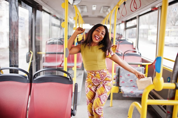 Jovem mulher afro-americana elegante andando de ônibus