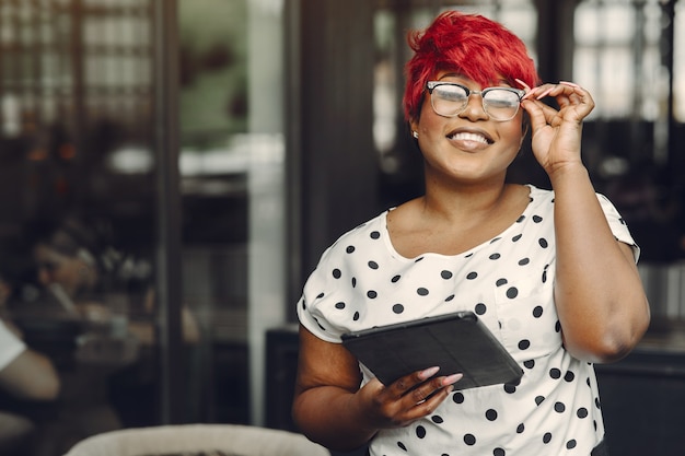 Jovem mulher afro-americana, trabalhando em um escritório. senhora em uma blusa branca.