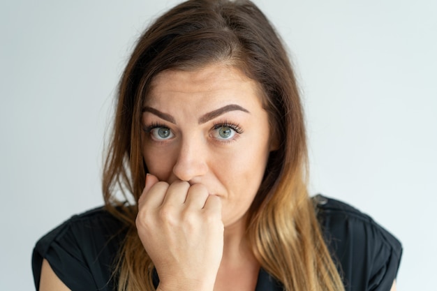 Jovem mulher ansiosa interessada que preocupa e que olha a câmera.