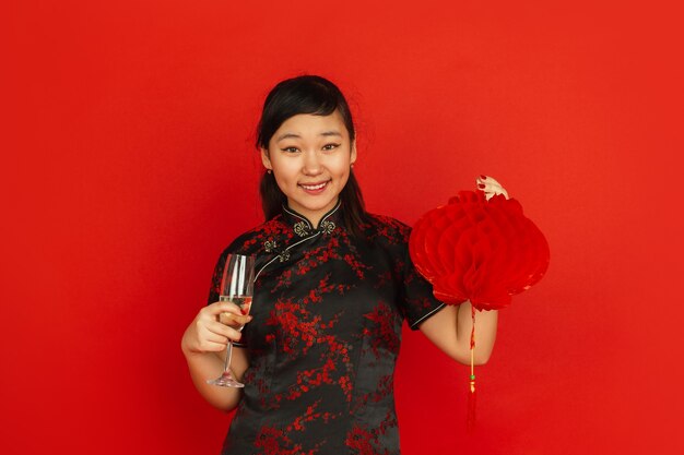 Jovem mulher asiática bebendo champanhe e segurando uma lanterna
