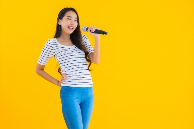 jovem mulher asiática cantando com microfone