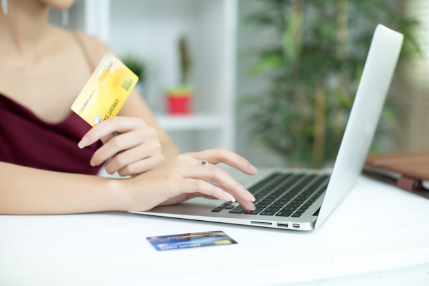 Jovem mulher asiática pagando com cartão de crédito