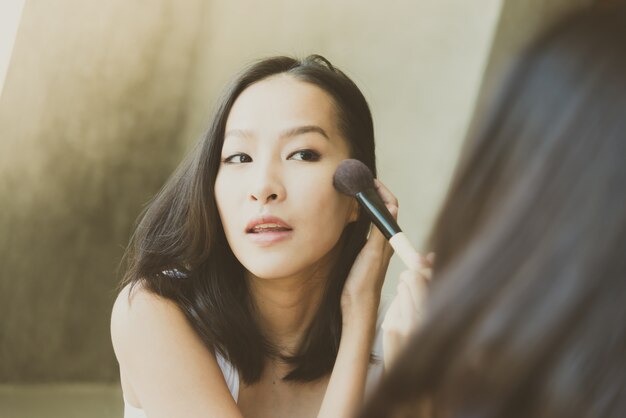 Jovem mulher asiática se maquiar