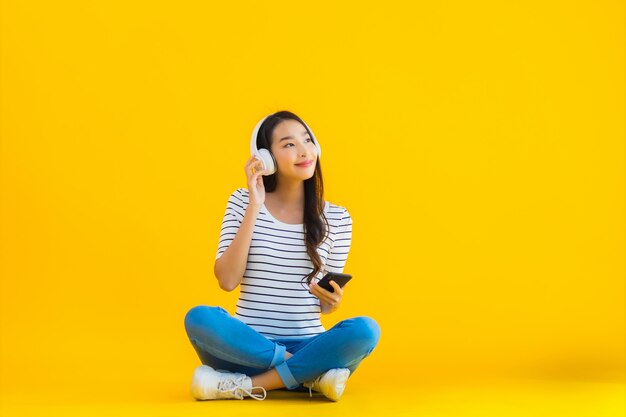 jovem mulher asiática usar telefone móvel esperto com fone de ouvido