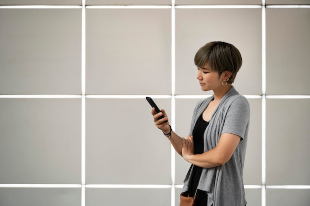 Jovem mulher asiática verificando o telefone