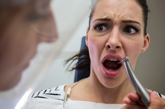 Jovem mulher assustada durante um check-up dental