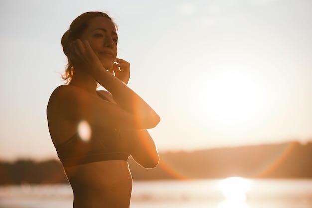 Jovem mulher atlética desfrutando enquanto trabalhava na natureza ao pôr do sol copiar espaço