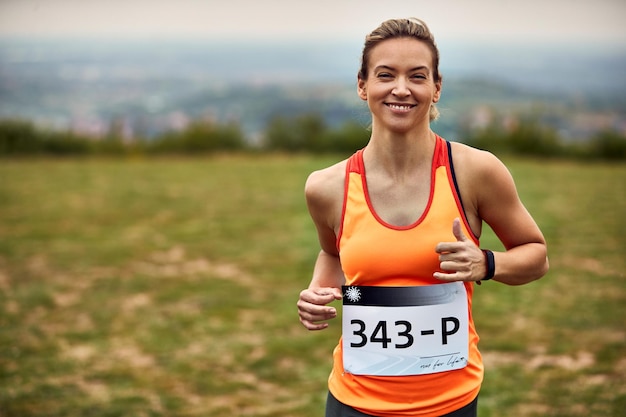 Foto grátis jovem mulher atlética feliz correndo uma maratona na natureza