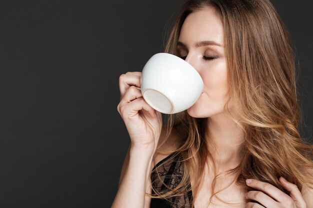 Jovem mulher atraente, bebendo café