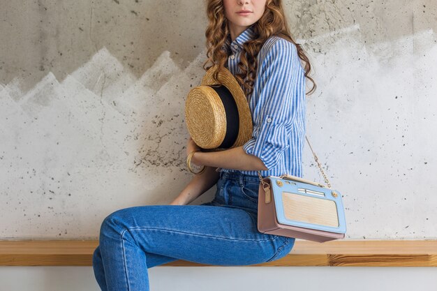 Foto grátis jovem mulher atraente e elegante sentada na parede