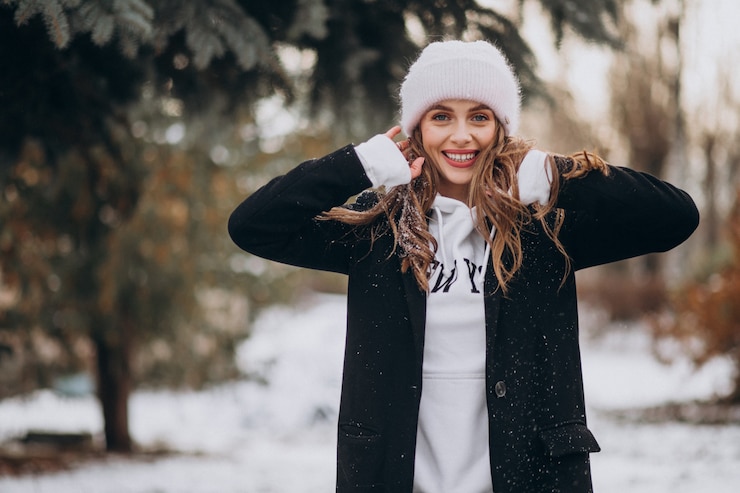 Foto grátis jovem mulher atraente em um parque de inverno com um chapéu fofo