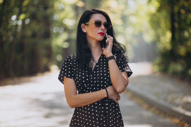 Jovem mulher atraente falando ao telefone no parque