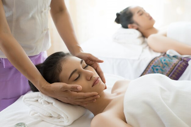 Jovem, mulher bonita, com massagem facial relaxante no spa.