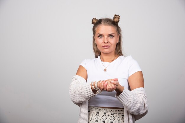 Jovem mulher bonita em roupa branca, segurando as mãos dela.