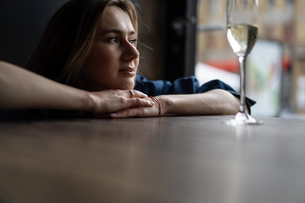 Jovem mulher bonita em um café, uma mulher bebendo champanhe em um café e conversando.