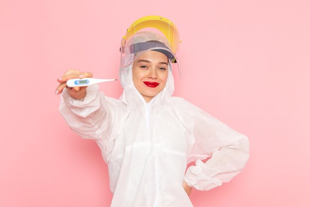 jovem mulher bonita em um terno branco especial segurando o dispositivo rosa