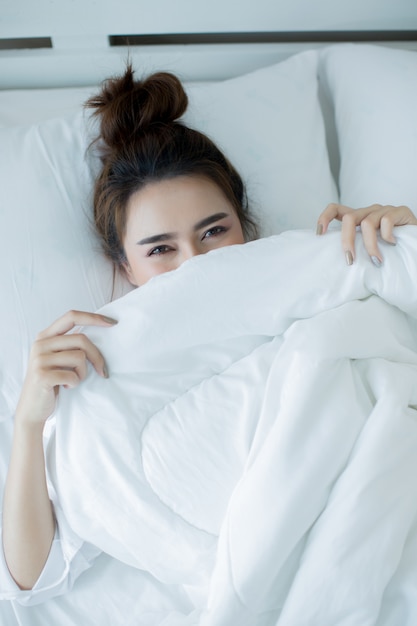 Jovem mulher bonita que encontra-se para baixo na cama e no sono.