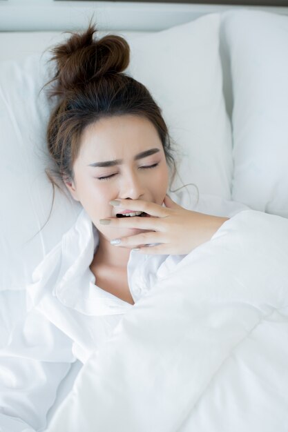 Jovem mulher bonita que encontra-se para baixo na cama e no sono.