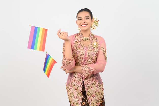 Jovem mulher bonita se veste na cultura local na região sul com bandeira do arco-íris