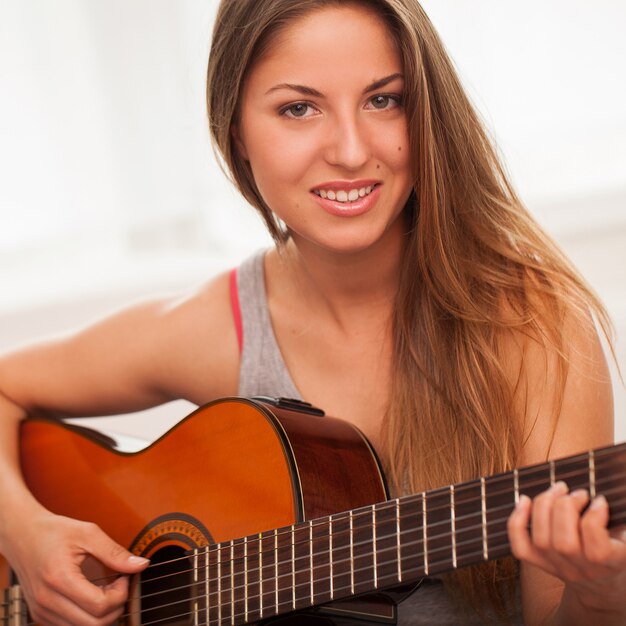 Jovem, mulher bonita, violão jogo