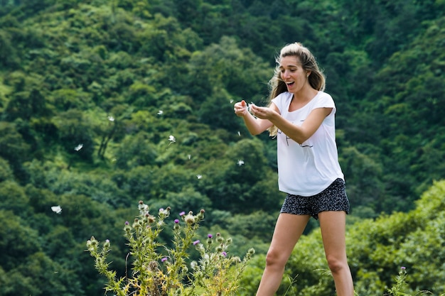 Jovem mulher brincando com pétalas de flores ao vento