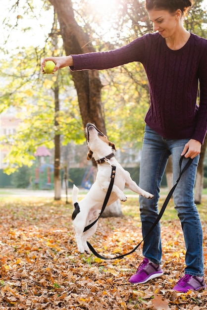 Jovem mulher brincando com seu cachorro